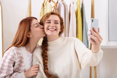 Photo of Beautiful young sisters taking selfie in dressing room