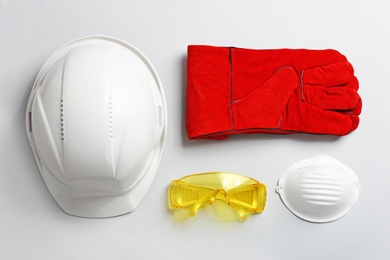 Photo of Flat lay composition with safety equipment on light background