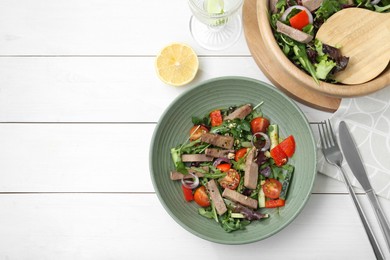Photo of Delicious salad with beef tongue and vegetables served on white wooden table, flat lay. Space for text