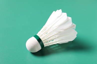 Photo of Feather badminton shuttlecock on green background, closeup