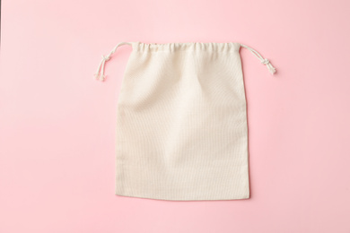 Photo of Cotton eco bag on pink background, top view