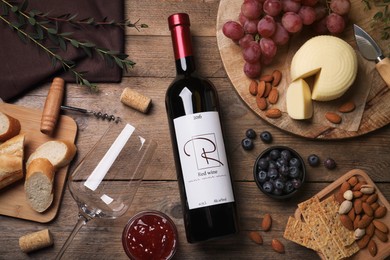Photo of Bottle of red wine with glass and appetizers on wooden table, flat lay