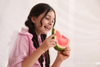 Photo of Cute little girl with watermelon on light background