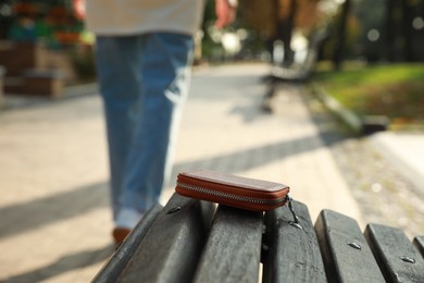 Woman lost her purse on wooden surface outdoors, selective focus. Space for text