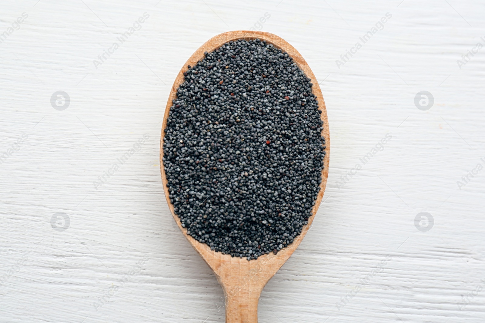 Photo of Poppy seeds in spoon on white wooden table, top view