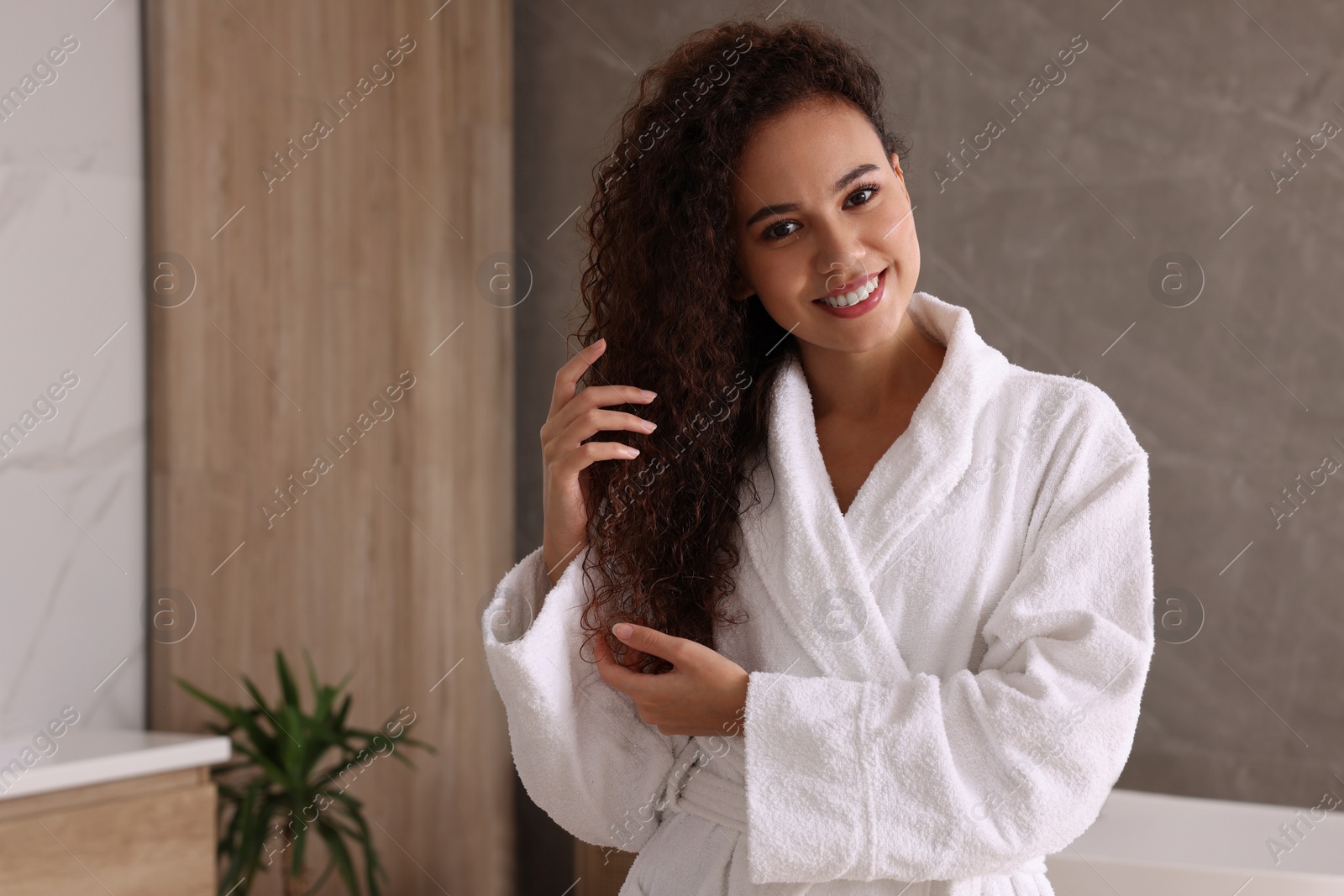 Photo of Beautiful African American woman in bathroom, space for text