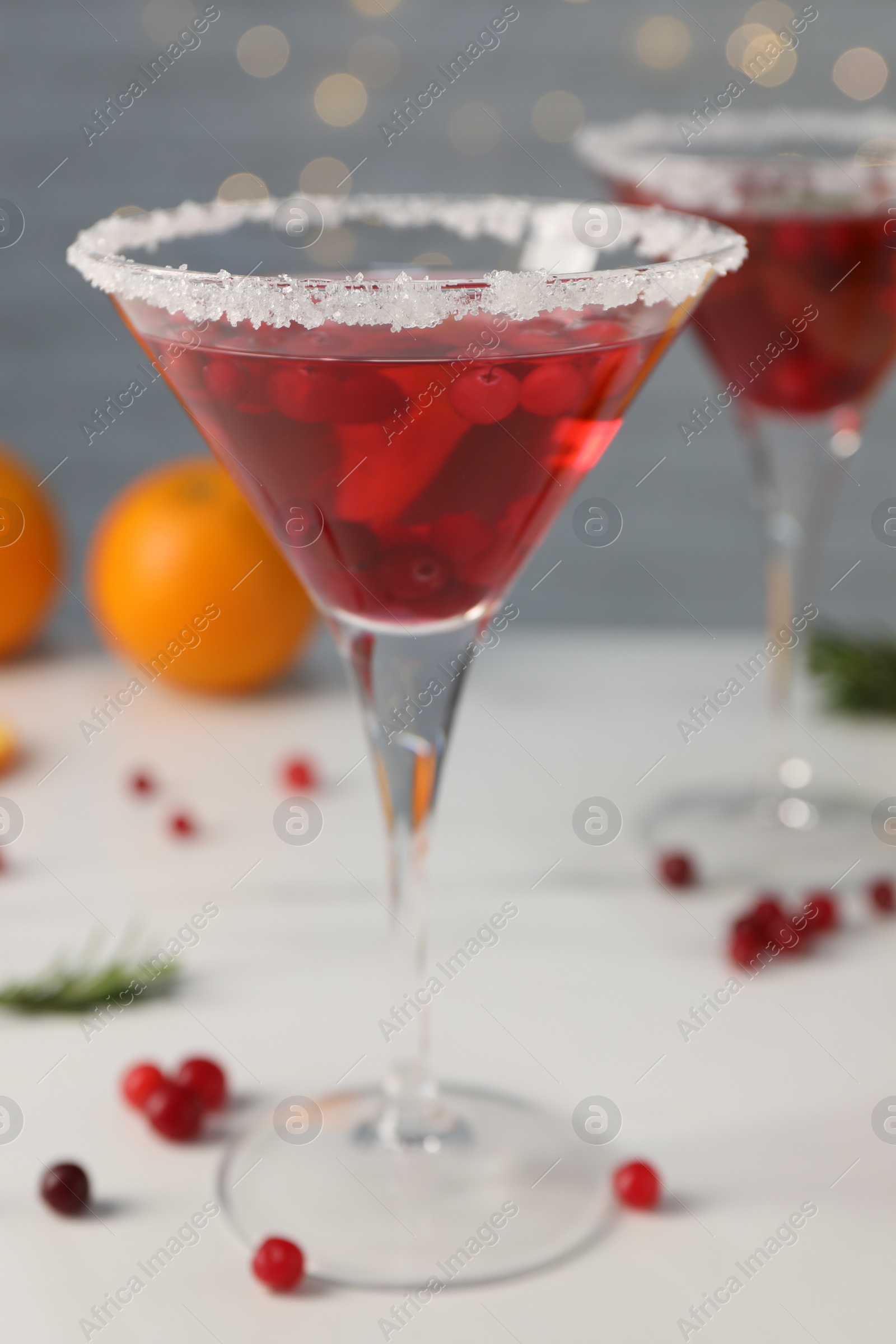 Photo of Tasty cranberry cocktail in glasses on light background, closeup