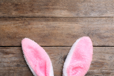 Decorative bunny ears and space for text on wooden background, flat lay. Easter holiday