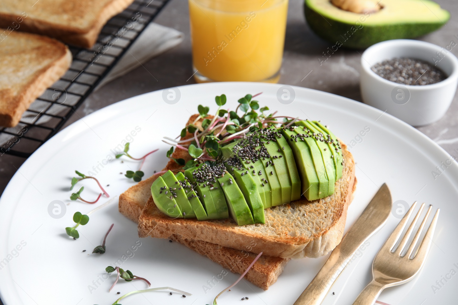 Photo of Tasty toasts with avocado, sprouts and chia seeds on plate