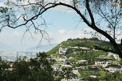 Picturesque view of trees, buildings and mountains in city