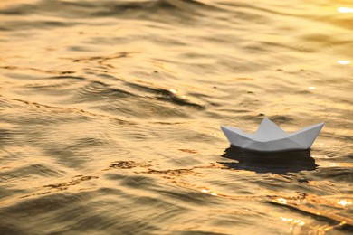 Paper boat floating on water outdoors. Space for text