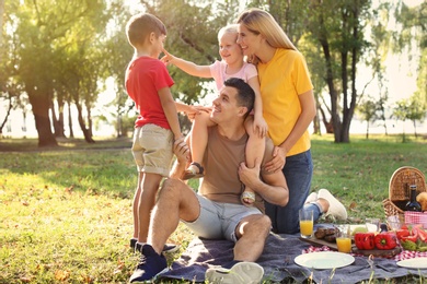 Happy family having picnic in park on sunny day