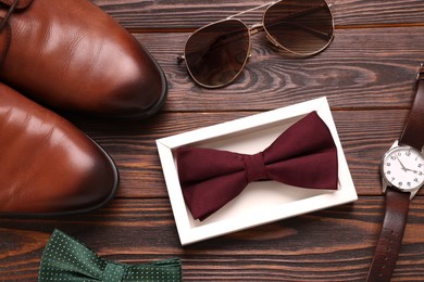 Flat lay composition with stylish color bow ties on wooden background