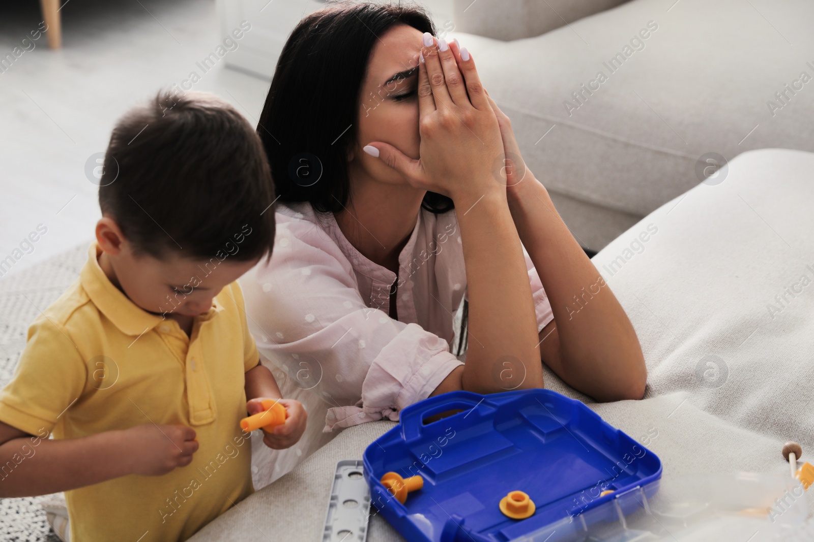 Photo of Depressed single mother with child in living room