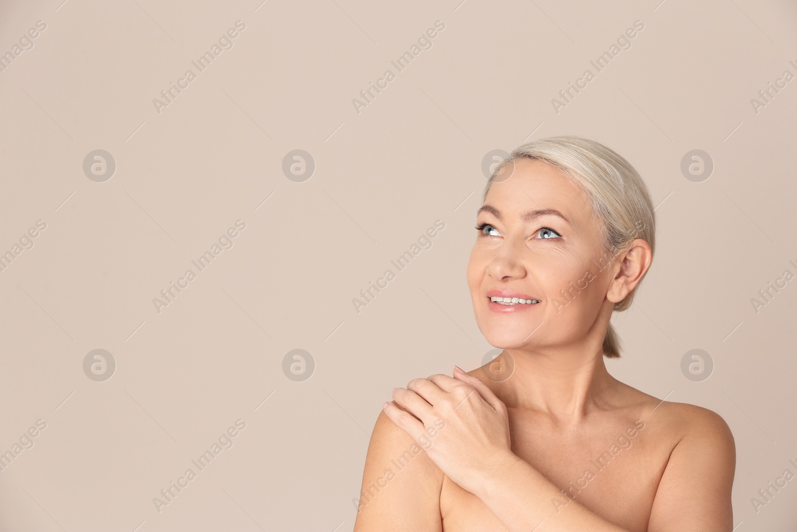 Photo of Portrait of beautiful mature woman on beige background. Space for text