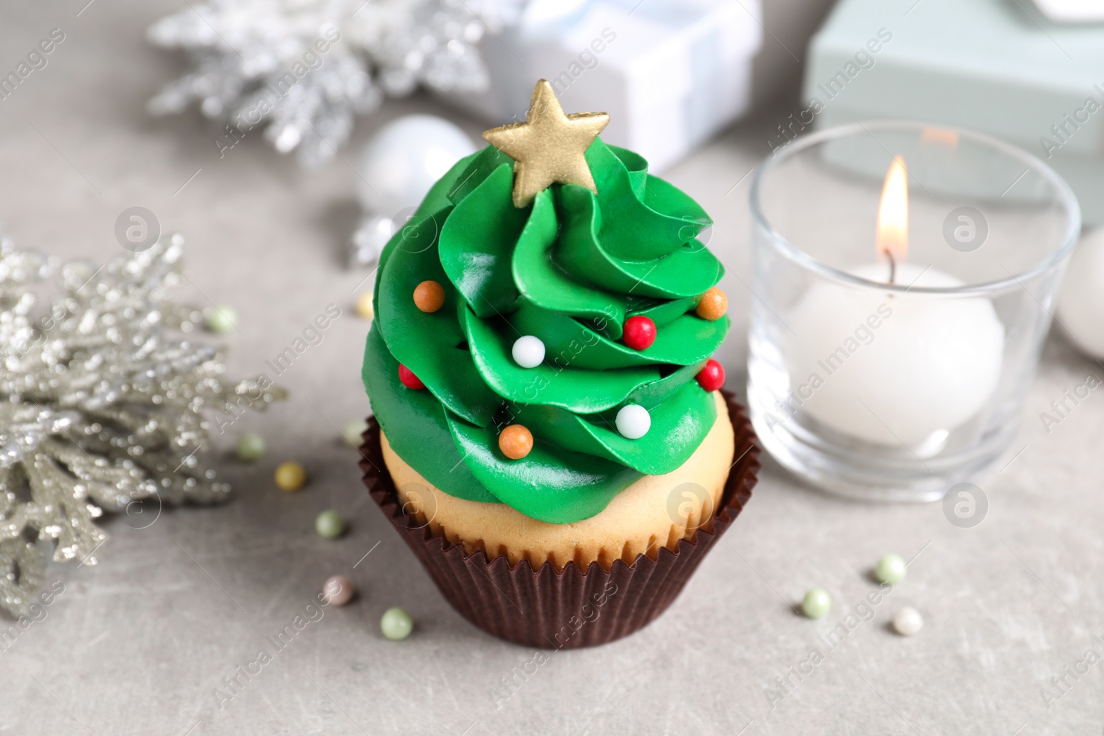 Photo of Christmas tree shaped cupcake on light grey table, closeup