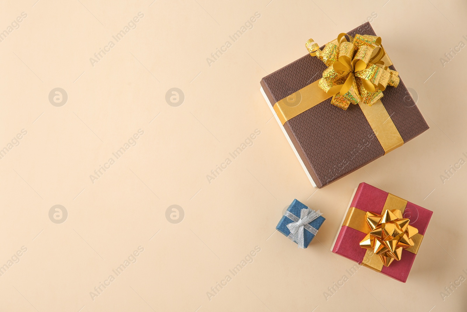 Photo of Beautiful gift boxes on beige background, flat lay. Space for text