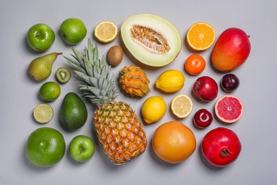 Many different fresh fruits on light grey table, flat lay
