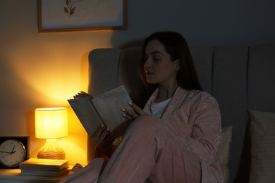 Beautiful woman reading before bed at night