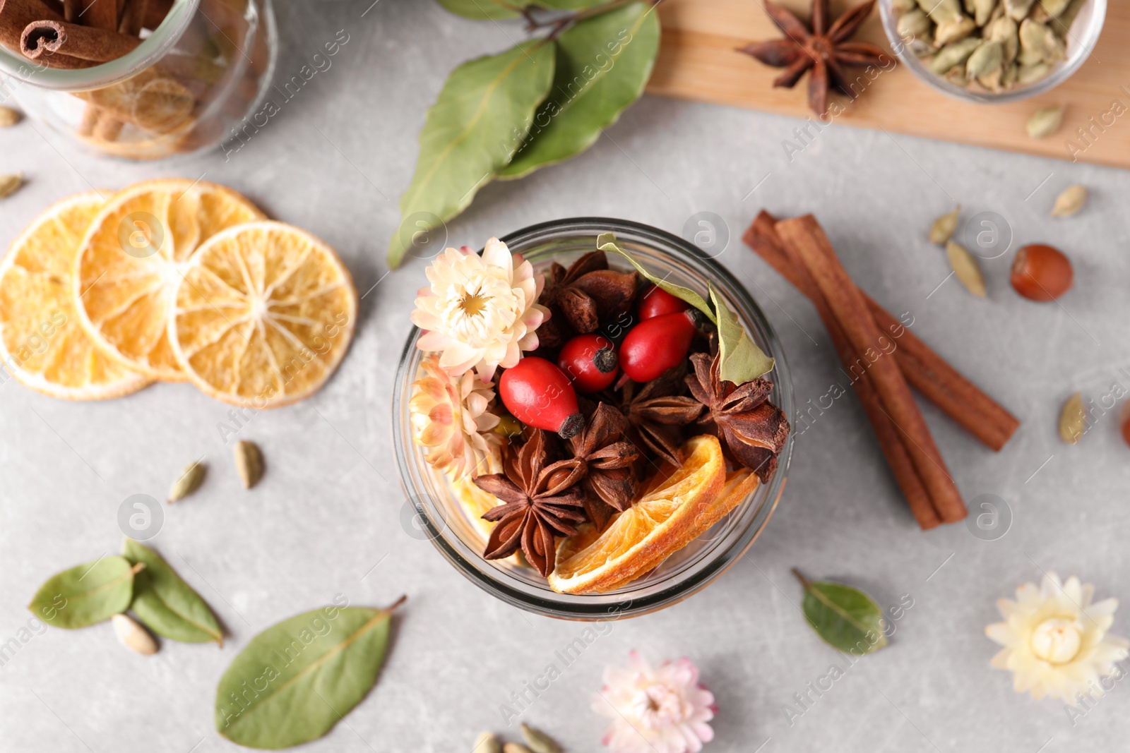 Photo of Aromatic potpourri in glass jar on light table, flat lay