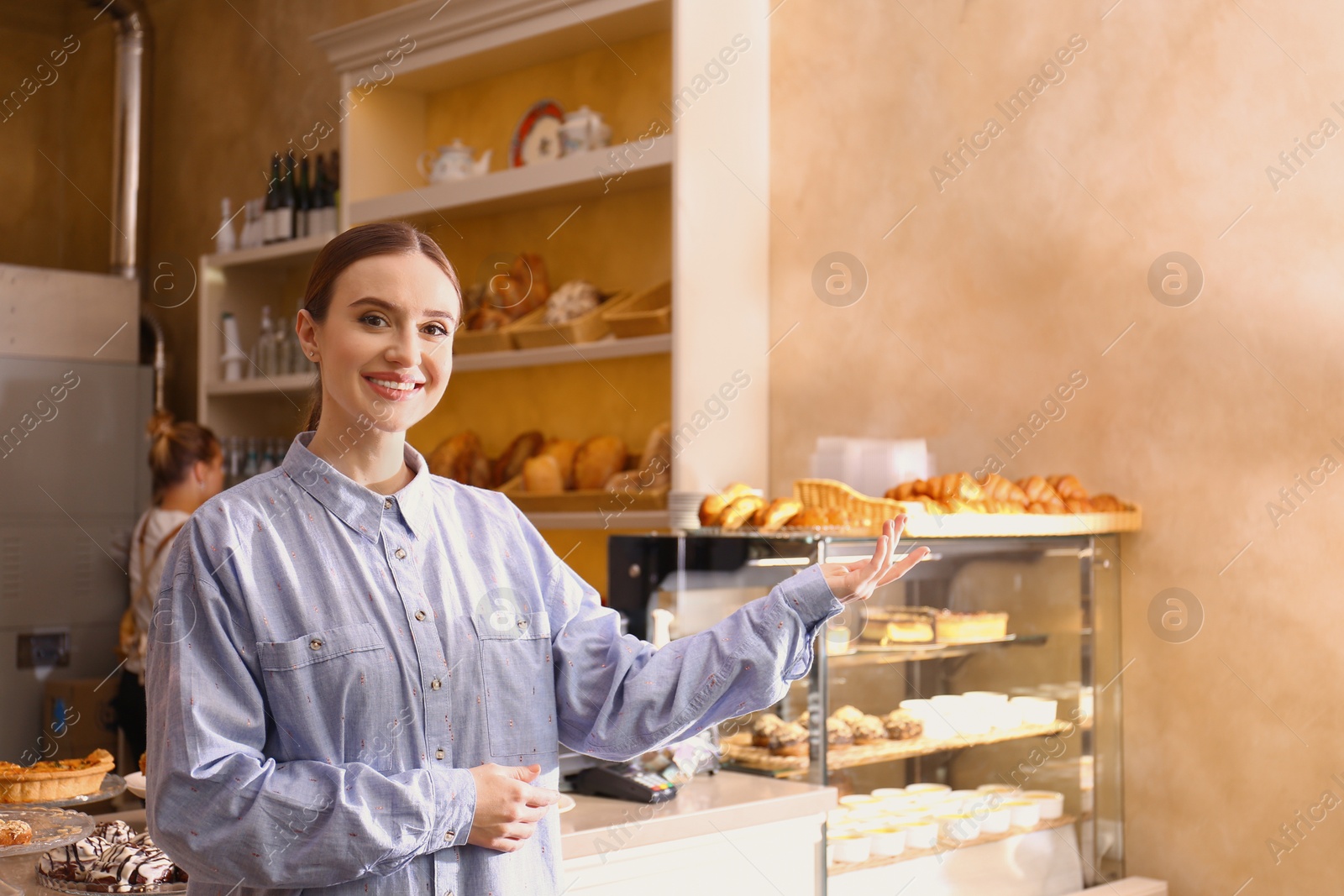 Photo of Female business owner showing products in her bakery