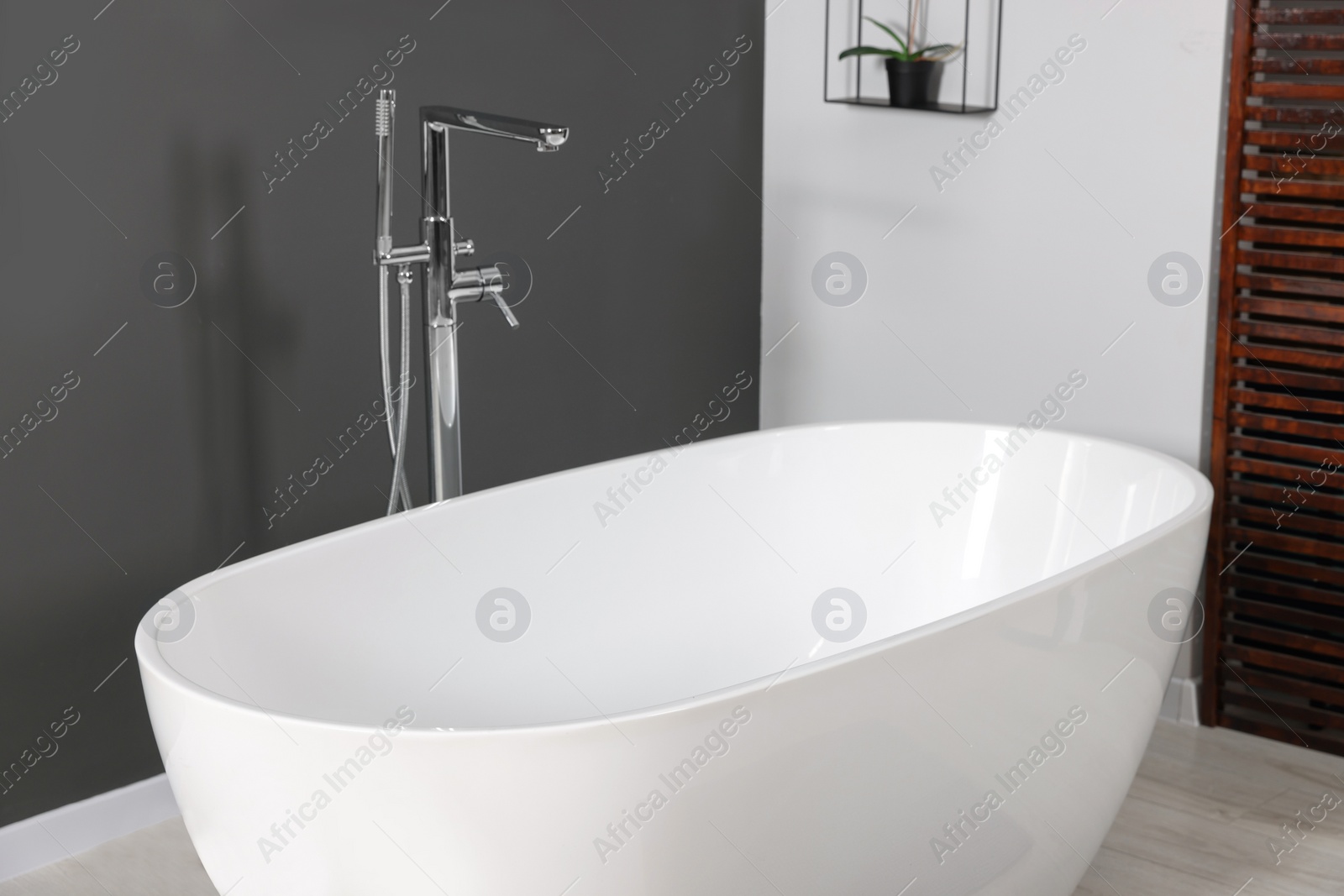 Photo of Stylish ceramic tub and modern tab in bathroom