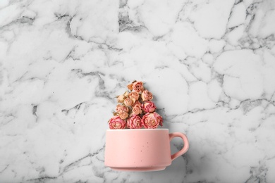 Photo of Flat lay composition with teacup and dried roses on marble background