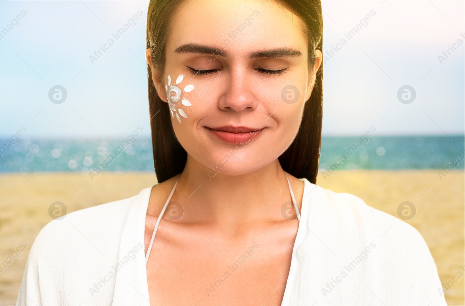 Image of Sun protection. Beautiful young woman with sunblock on her face near sea, closeup