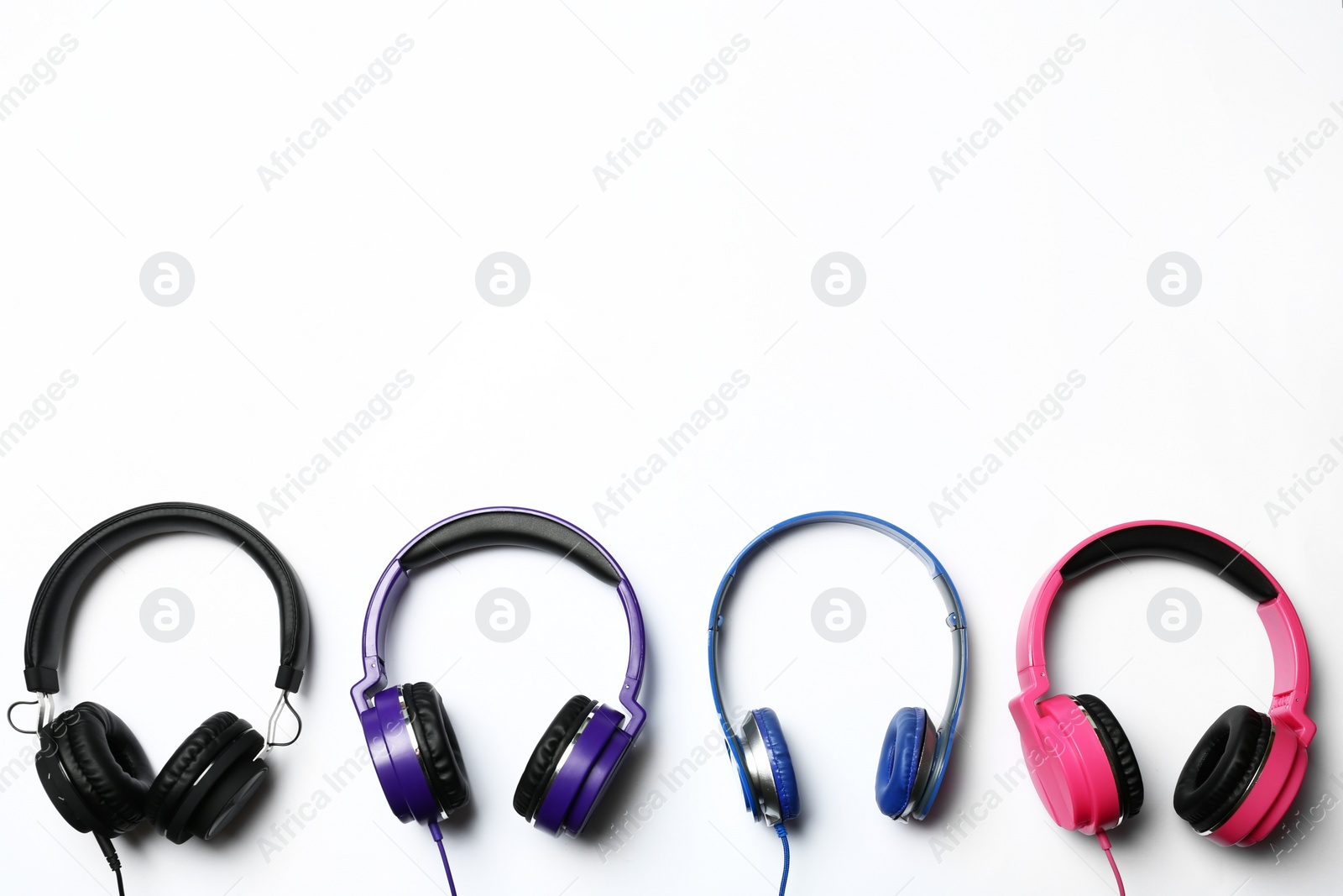 Photo of Many stylish headphones on white background, top view