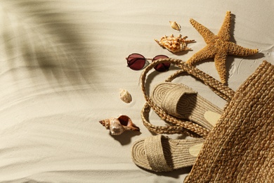 Photo of Different beach accessories on sand, flat lay. Space for text