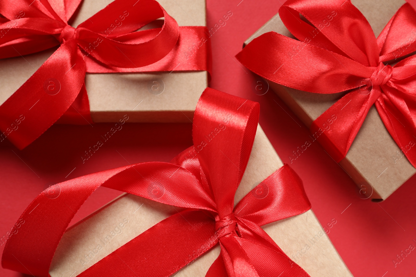 Photo of Beautiful gift boxes on red background, closeup