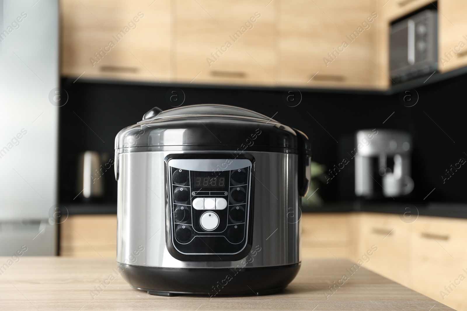 Photo of Modern multi cooker on wooden table in kitchen