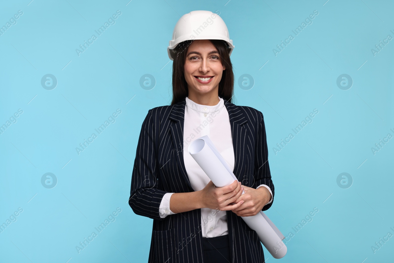 Photo of Architect in hard hat with draft on light blue background