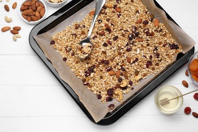 Photo of Tray with tasty granola, nuts and dry fruits on white wooden table, flat lay