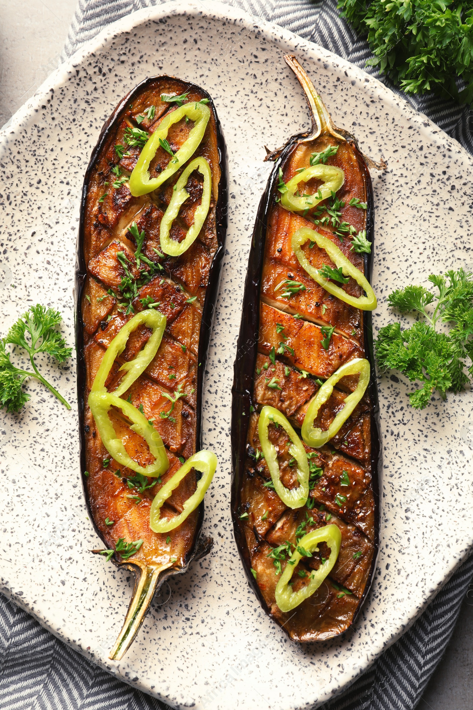 Photo of Fried eggplant slices with chili peppers on plate, closeup