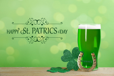 Image of Green beer, horseshoe and clover leaves on wooden table. St. Patrick's Day celebration