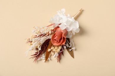 Photo of Stylish boutonniere on beige background, above view