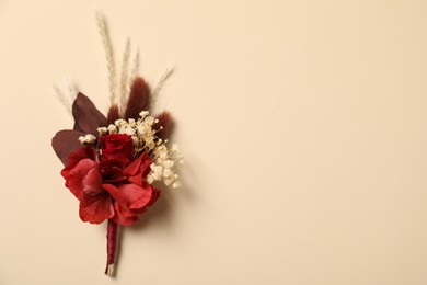 Photo of Stylish red boutonniere on beige background, top view. Space for text