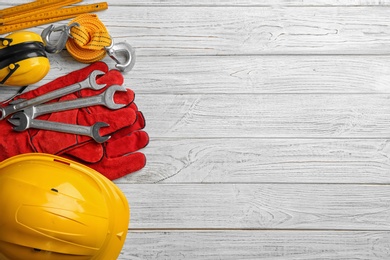 Photo of Flat lay composition with different construction tools and space for text on white wooden background