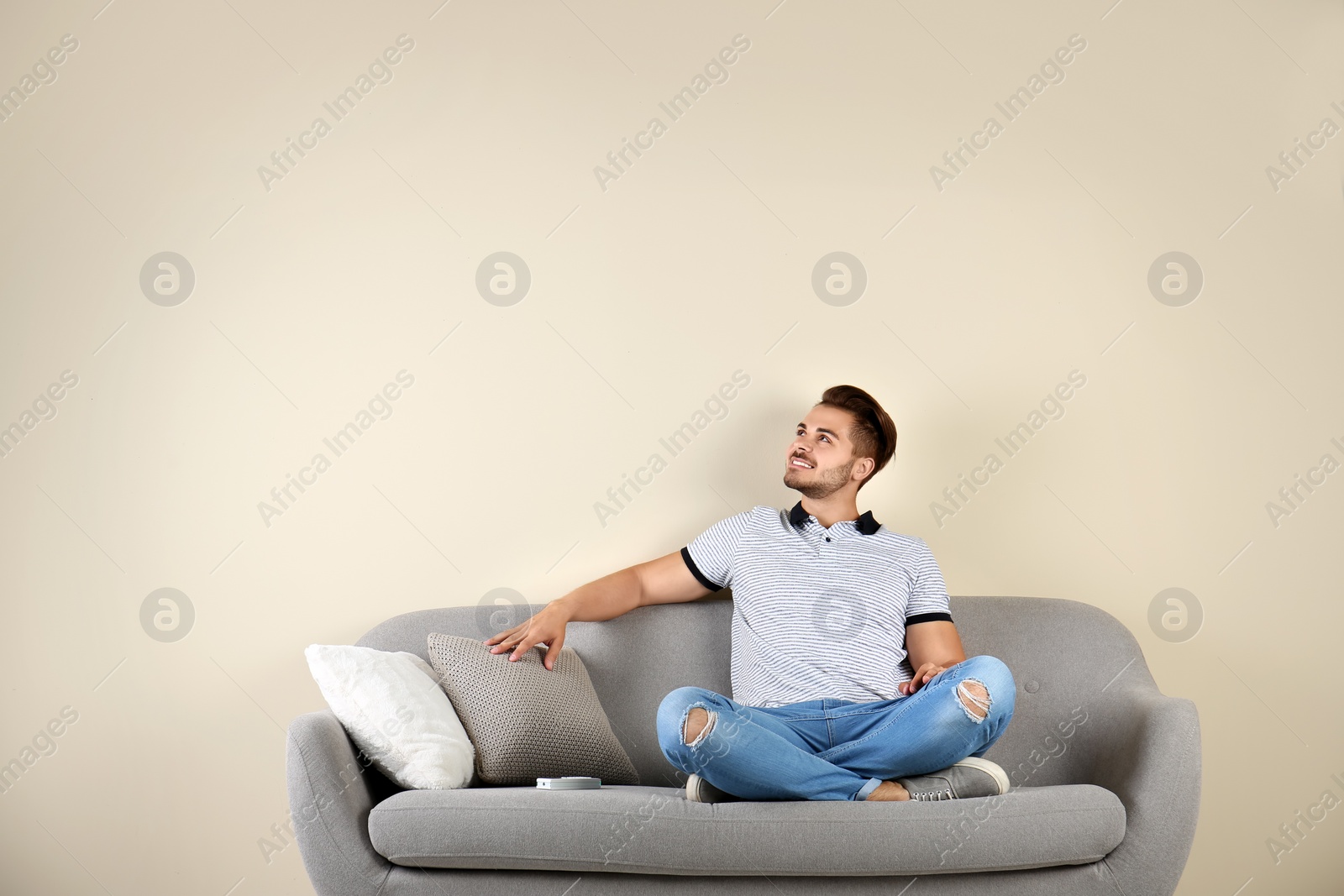 Photo of Young man with air conditioner remote at home