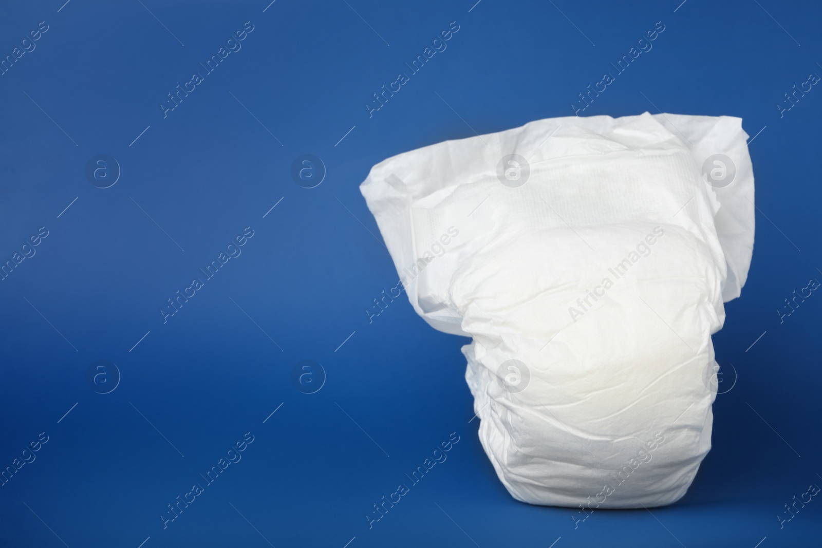 Photo of Baby diaper on blue background. Space for text