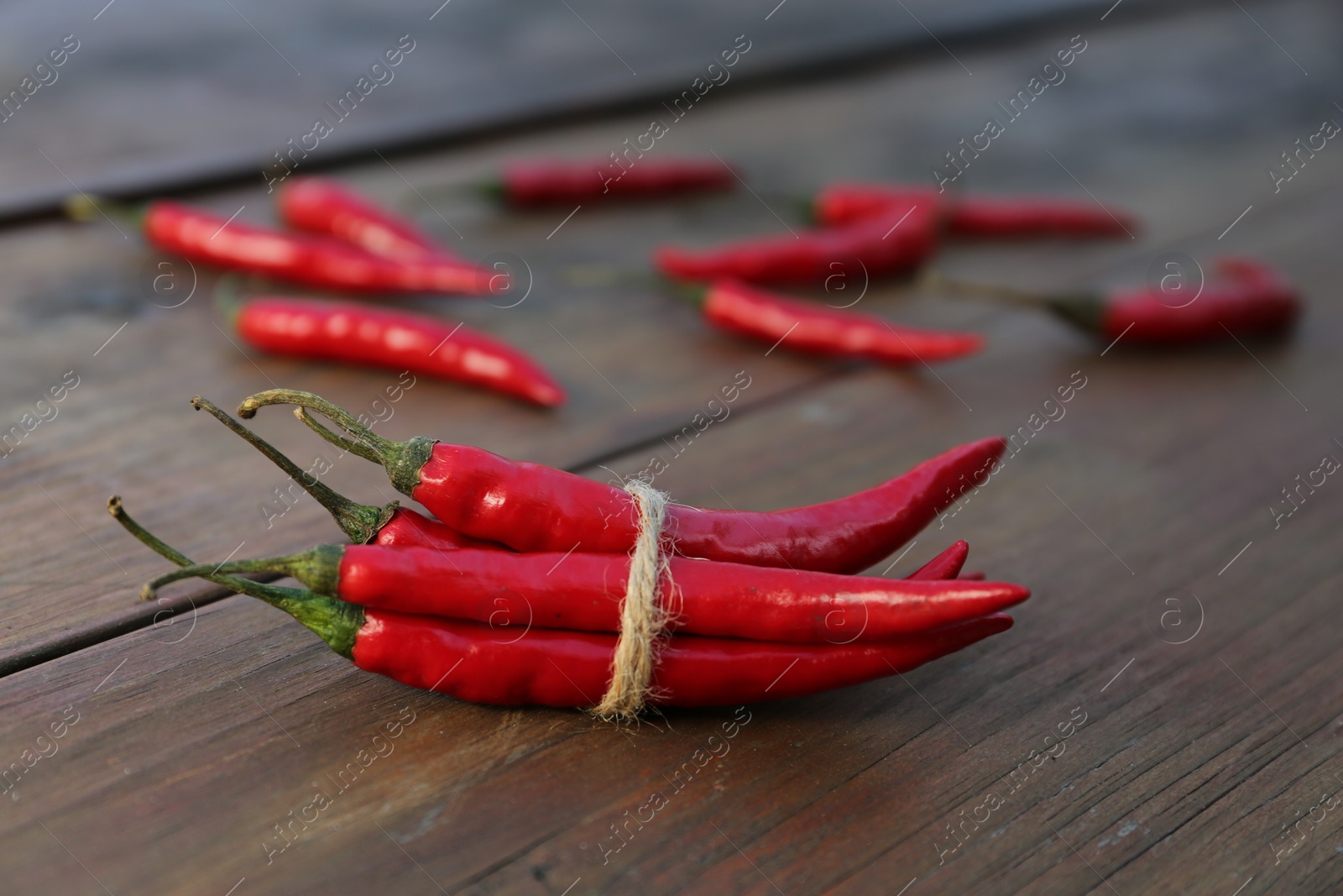 Photo of Fresh ripe chili peppers on wooden table