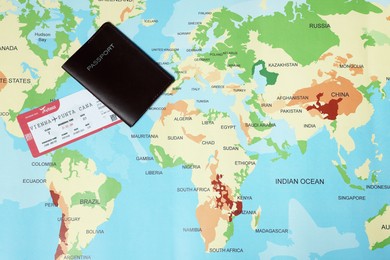 Photo of Passport and ticket on world map, flat lay