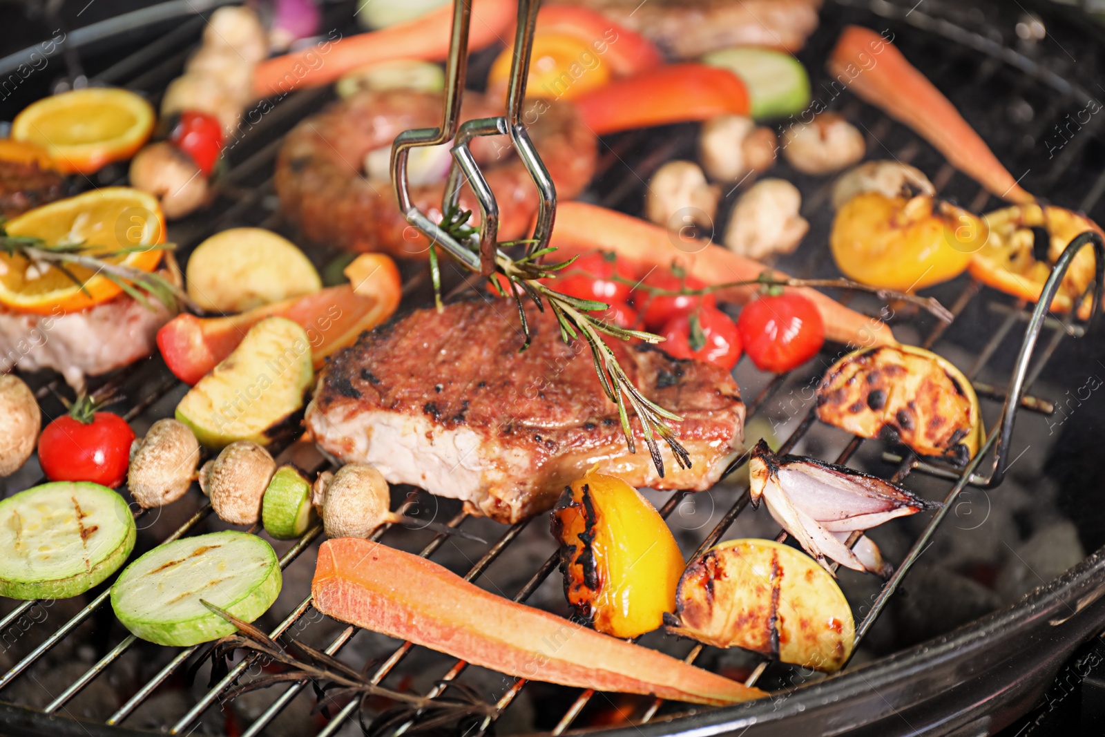 Photo of Cooking delicious meat and vegetables on barbecue grill, closeup