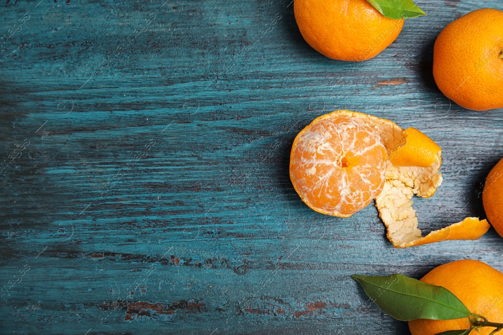 Photo of Fresh ripe tangerines and space for text on wooden background, top view