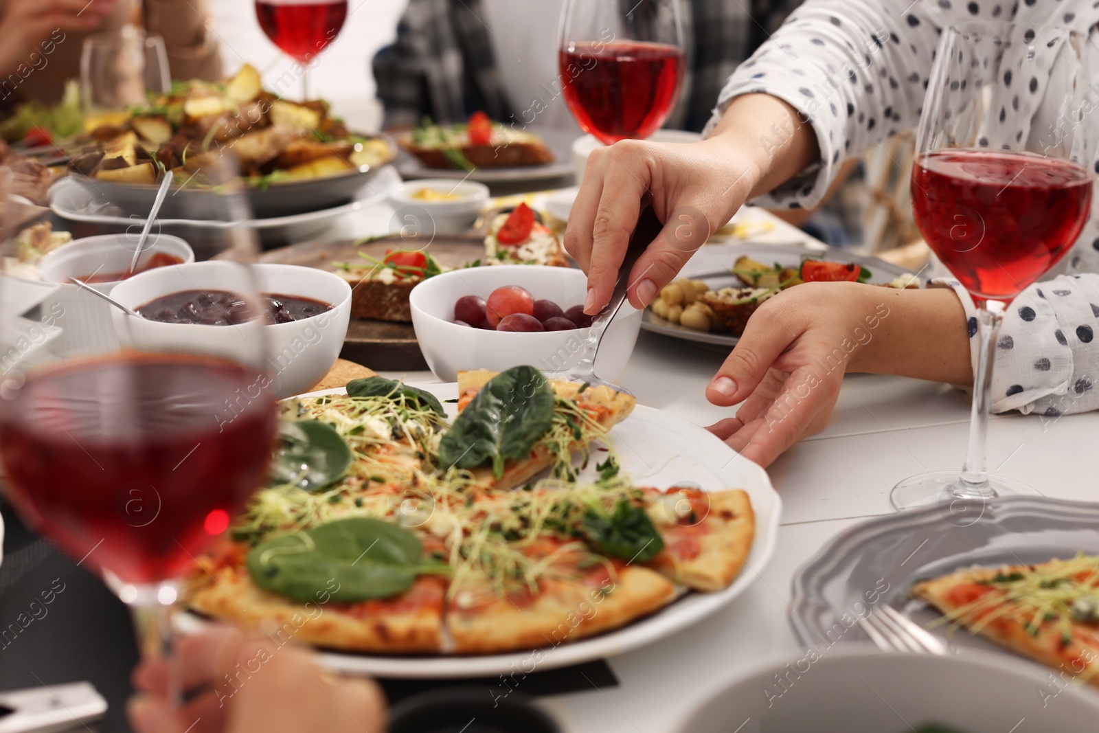 Photo of Woman taking slice of pizza during brunch at table, closeup