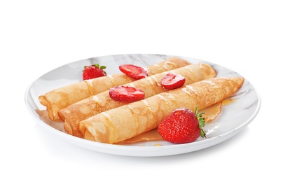 Plate with tasty thin pancakes and fresh berries on white background