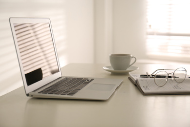 Photo of Modern laptop on office table. Stylish workplace