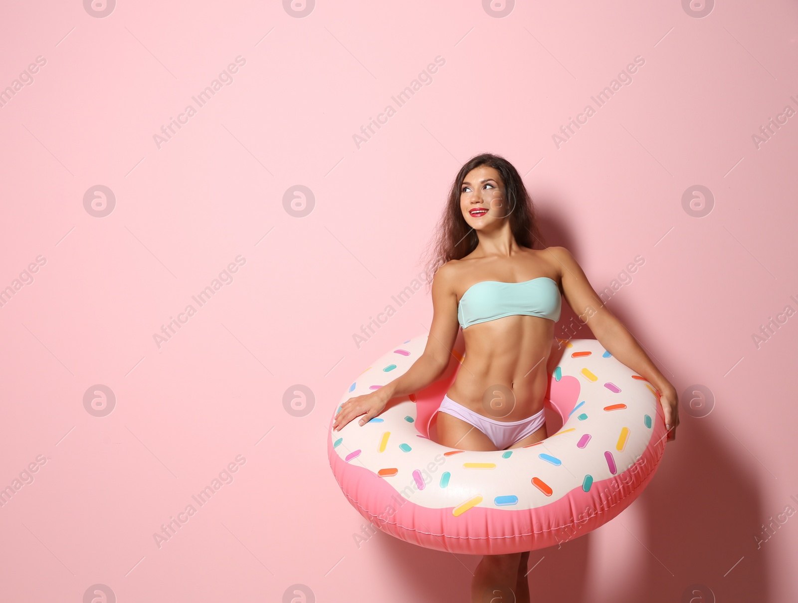 Photo of Beautiful young woman with inflatable ring on color background