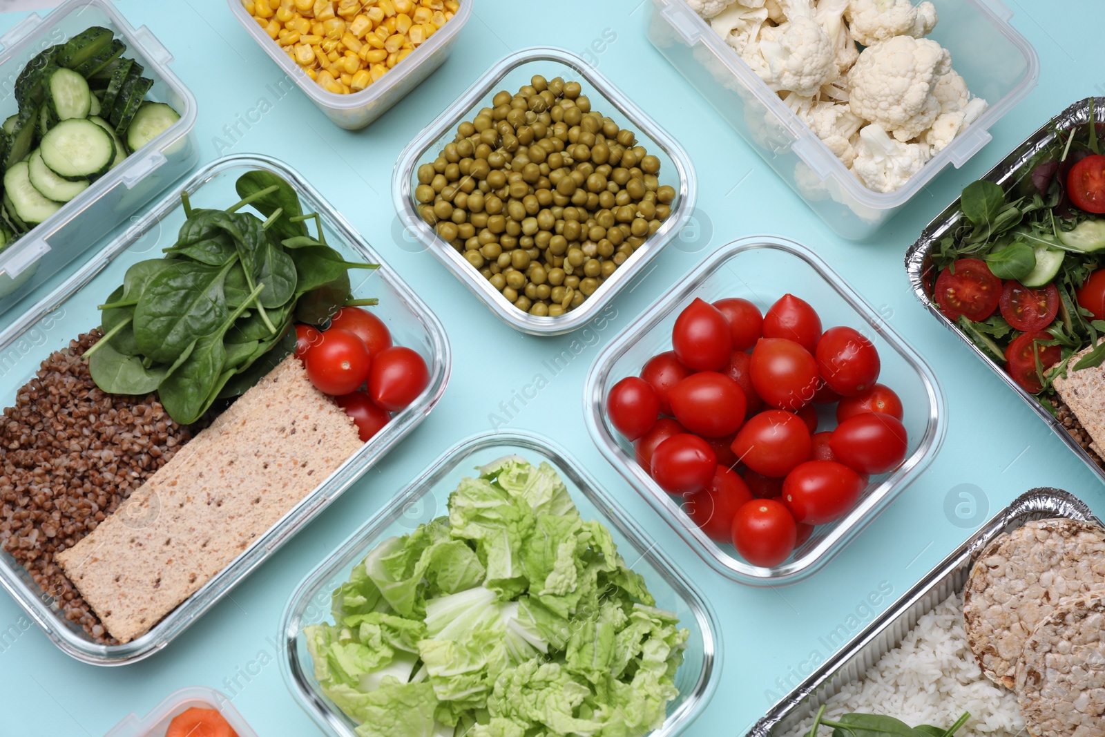 Photo of Different containers with fresh products on light blue background, flat lay